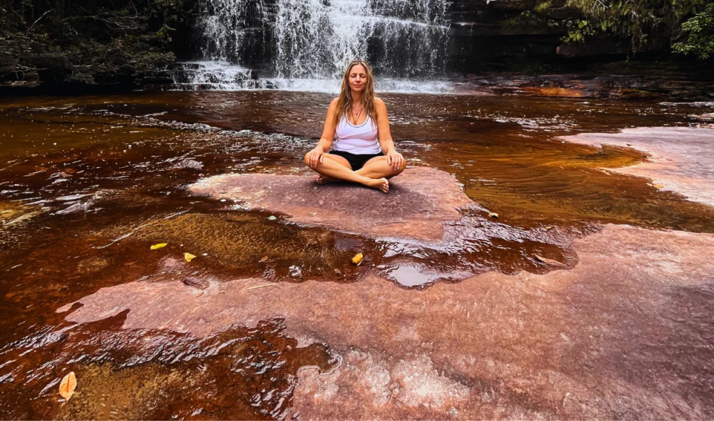 Mulher toma banho de Cachoeira enquanto medita no rio Funis, Chapada Diamantina.