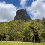 Foto panorâmica do Morro do Castelo, céu azul e vegetação ao fundo