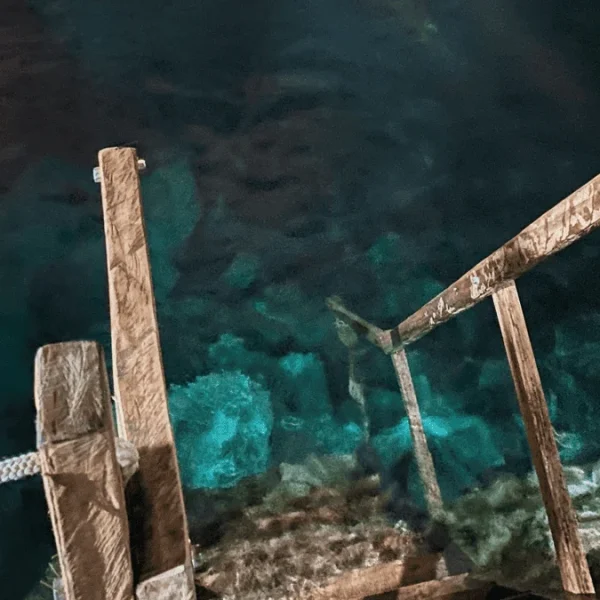 Escadas e poço azul ao fundo, na Chapada Diamantina.